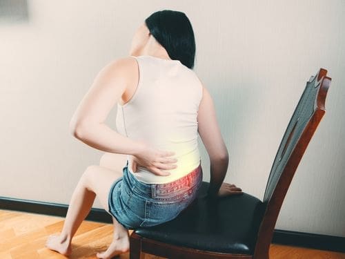 Donna si tocca la schiena a causa di un dolore