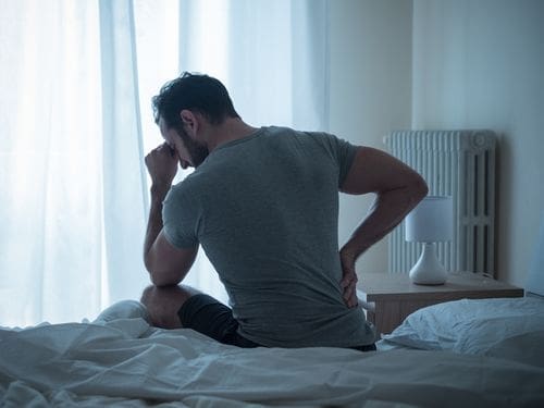 Uomo dolorante si tocca la schiena