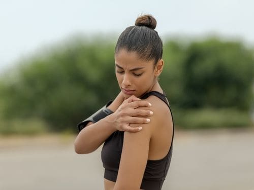 Numerose sono le cause che possono provocare la lussazione alla spalla: scopri le principali! Donna si tocca la spalla a causa di un dolore