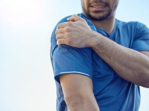 Scopri come riconoscere i sintomi riconducibili alla lussazione della spalla! Uomo si tocca la spalla a causa di un dolore