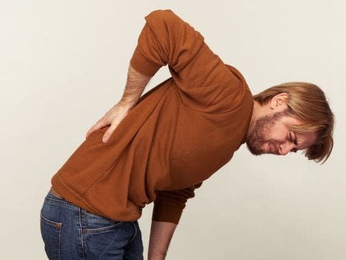 Uomo si tocca la schiena dolorante