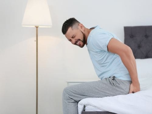 Uomo si tocca la schiena dolorante